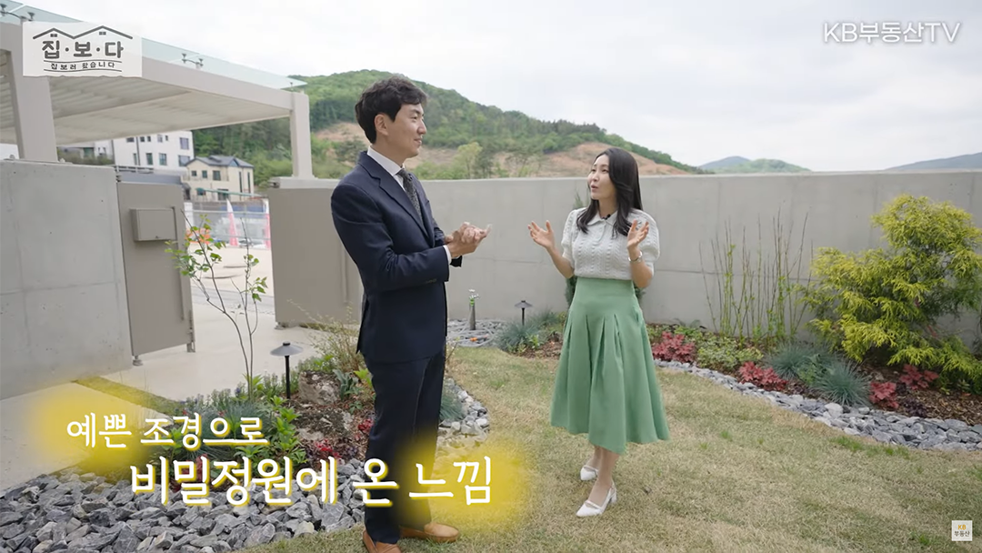 '집.보.다'가 방문한 '모스만코트 샘플하우스'의 마당을 보여주고있음. 예쁜 조경으로 비밀정원에 온 느낌이고, 높은 담장으로 보안성도 높임.