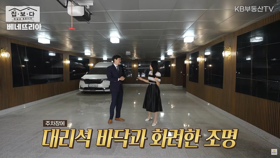 KB부동산TV 집.보.다 컨텐츠의 '베네뜨리아' 편의 한 장면이다. '베네뜨리아' 주택의 대리석 바닥과 화려한 조명이 있는 주차장을 보여주고 있다.