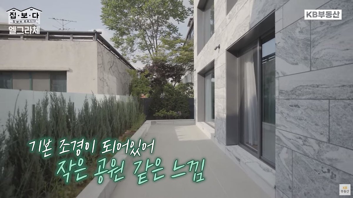 'KB부동산TV 집.보.다' 컨텐츠 '엘그라체 연희' 편의 한 장면이다. '엘그라체 연희'의 기본 조경이 되어있어 작은 공원같은 느낌이 드는 야외 테라스를 보여주고 있다.