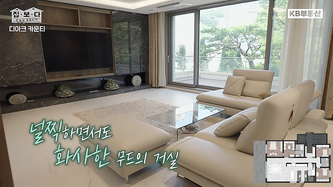 KB부동산TV 집.보.다 컨텐츠의 '디아크 카운티' 편의 한 장면이다. '디아크 카운티' 주택의 널찍하고 화사한 무드의 거실을 보여주고 있다.