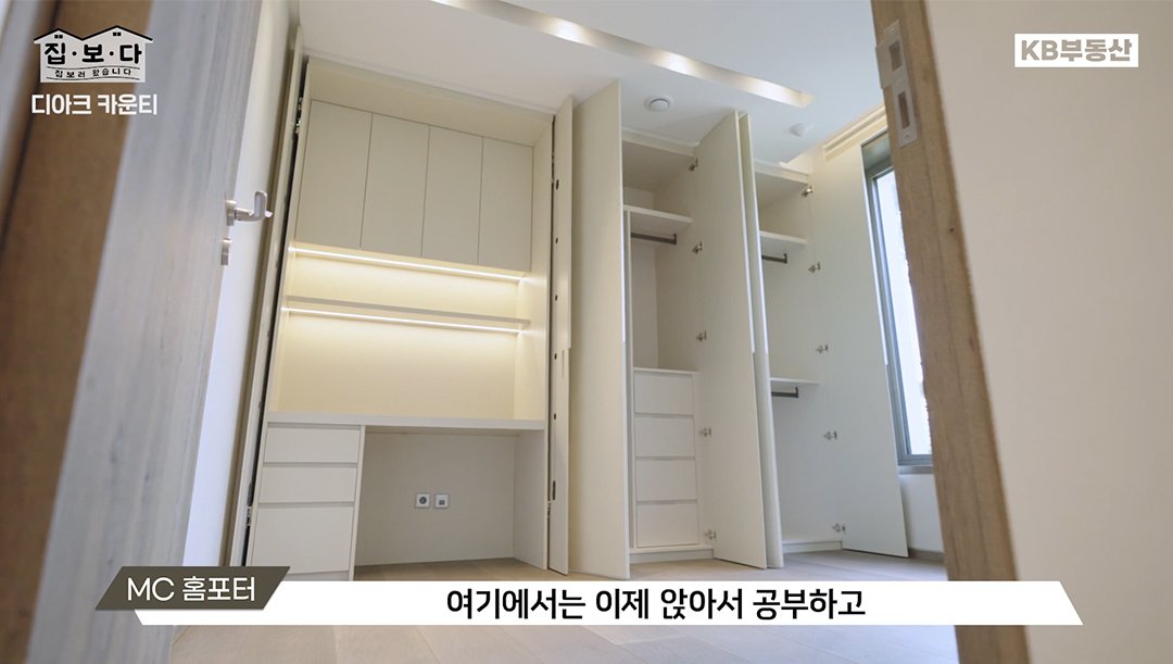 KB부동산TV 집.보.다 컨텐츠의 '디아크 카운티' 편의 한 장면이다. '디아크 카운티' 주택의 안쪽에 책상이 마련된 붙박이장이 있는 서브룸을 보여주고 있다.