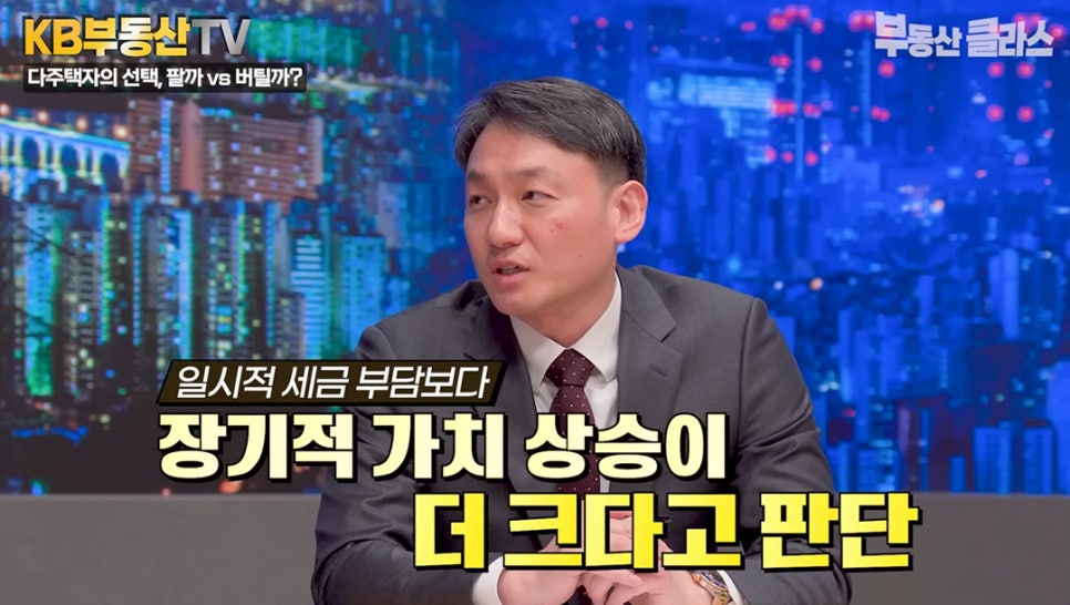 KB부동산 TV 방송 화면에서 전문가가 '일시적 세금 부담보다 장기적 가치 상승이 더 크다고 판단'이라는 자막과 함께 다주택자의 선택에 대해 설명하는 모습이다.