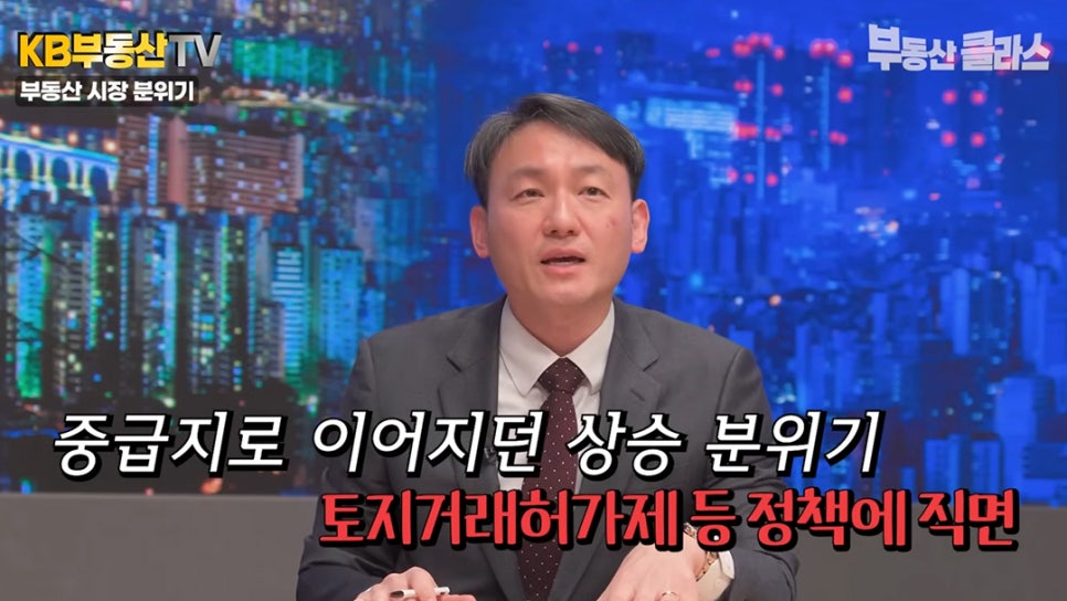 전문가가 '중급지로 이어지던 상승 분위기, 토지거래허가제 등 정책에 직면'이라는 자막을 통해 정책 변화가 부동산 시장의 상승 흐름에 미치는 영향에 대해 발언하는 장면이다.