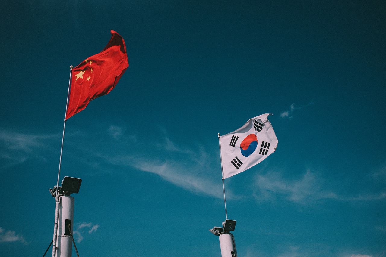 파란 하늘을 배경으로 '태극기'와 중국 국기가 위치해있다.