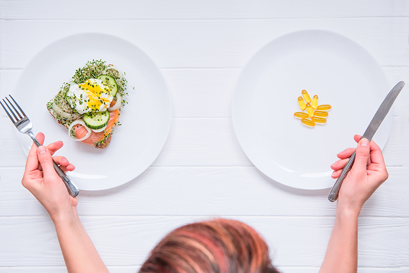 머리 위에서 내려 찍은 각도. 하얀 식탁 위 하얗고 '둥근 접시' 두 개에 '음식' 담겨있다. 사람 정수리와 양손에 들린 나이프와 포크가 보임.
