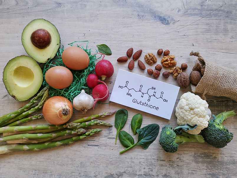 나무 바닥 위 널브러진 각종 채소와 견과류, 그 가운데 'Glutathione'라 적힌 하얀 명함이 있다. '글루타치온' 함유, 양파, 계란, 아보카도, 브로콜리, 호두, 아몬드 등.