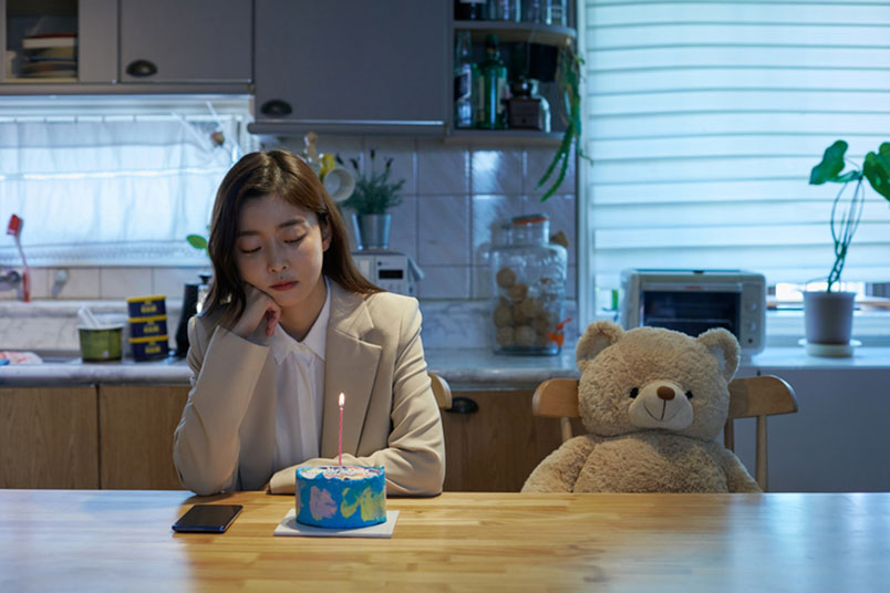 홀로 케잌에 불을 키고 생일을 보내고 있는 '외로운 모습'의 여자이다.