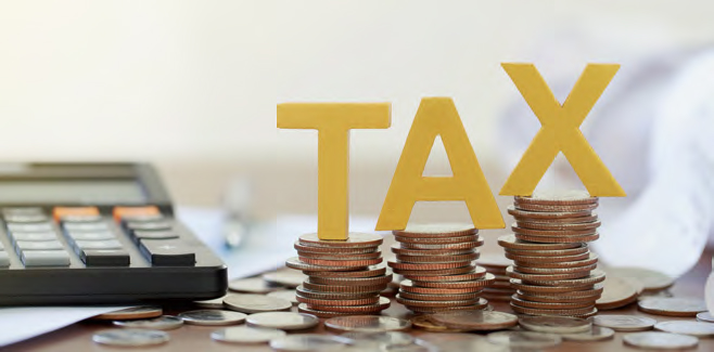 동전이 쌓여있는곳 위에 'TAX'글자가 놓여있다.