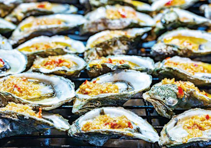 긴 가판대에 '양념을 올린 굴' 등 길거리 음식이 진열된 모습이다.