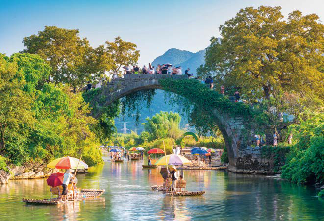 전통 '대나무 뗏목'을 타고 잔잔한 위룽허 강물을 유유자적 떠내려가는 모습이다.