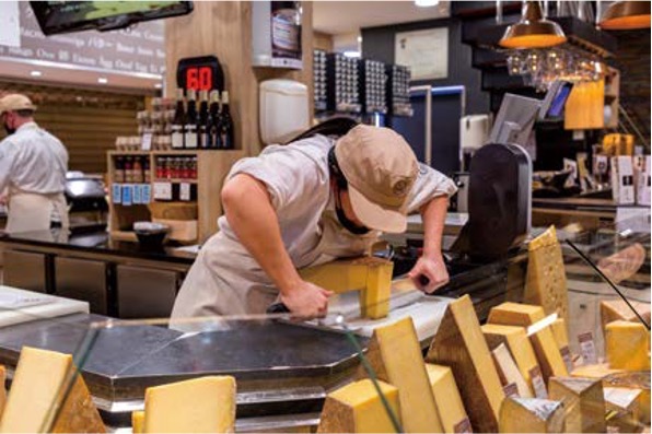 리옹 최대 식료품 시장인 ‘폴 포퀴즈 시장’에서 상인이 커다란 치즈 덩어리를 온 힘을 다해 자르고 있다.
