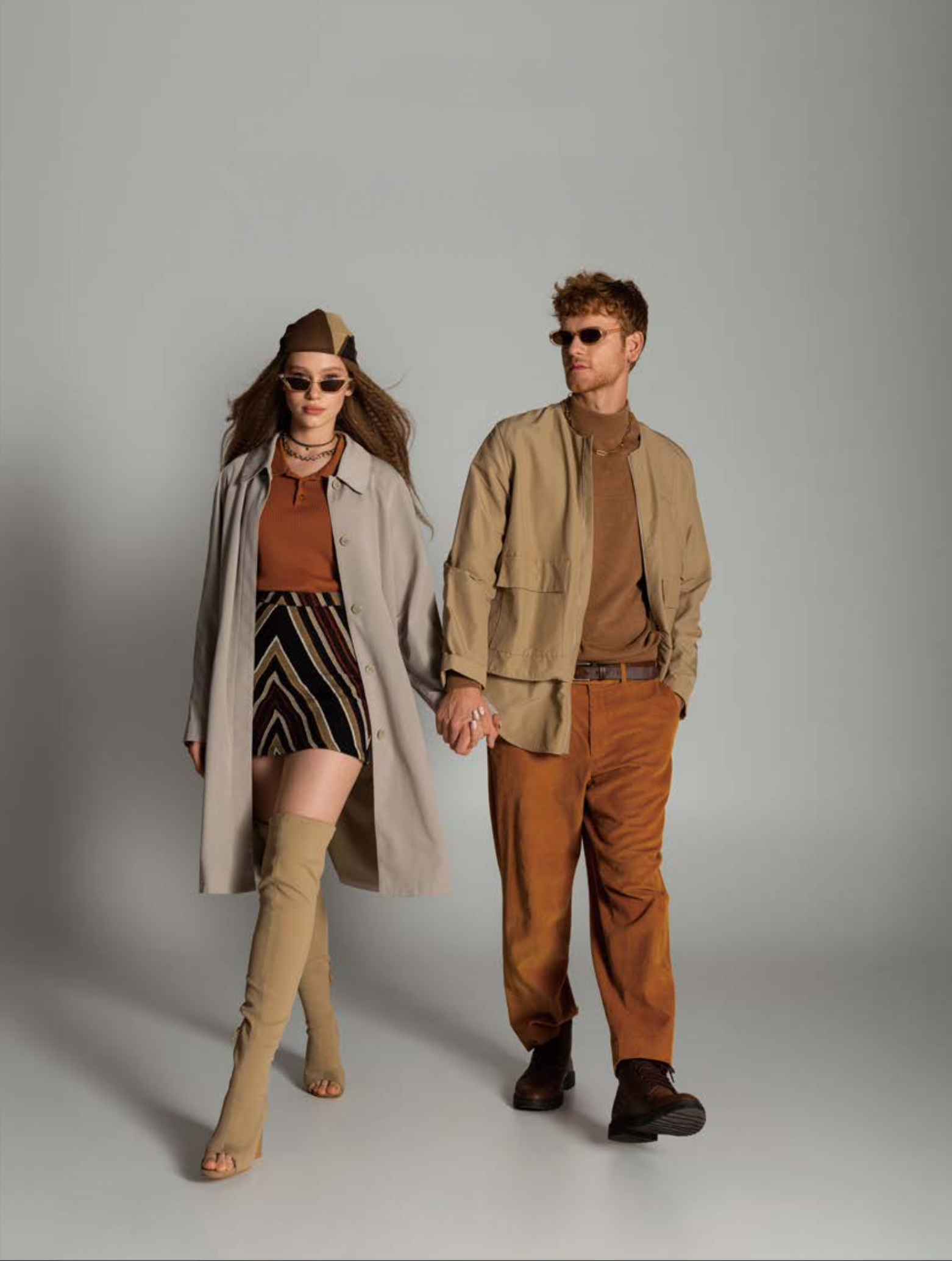 남녀 두 명의 모델이 브라운 톤의 옷을 입고 포즈를 취하고 있다.