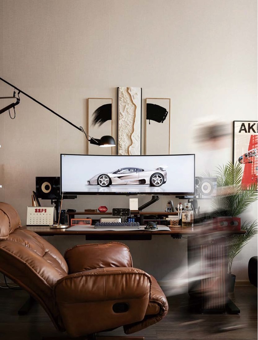 '와이드 모니터와 브라운 가죽 리클라이너'가 있는 '세련된 홈 오피스' 이미지입니다.