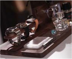 '우드 트레이 위에 정돈된 손목시계, 안경, 향수 등 개인 소품'들입니다.