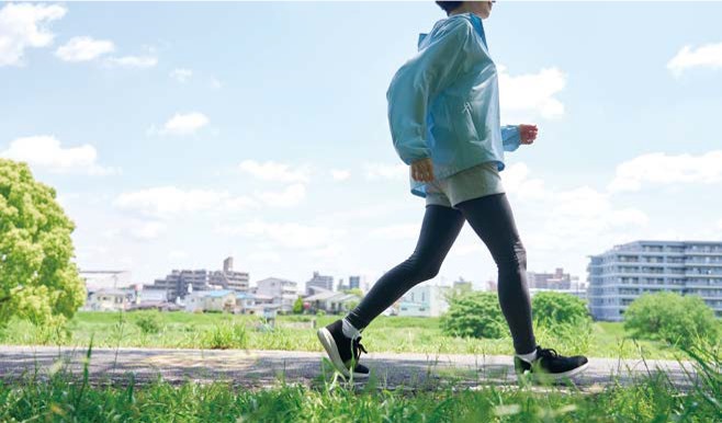 '공원 산책로에서 운동복 차림으로 가볍게 걷기 운동을 하는 사람의 측면 모습'이다.