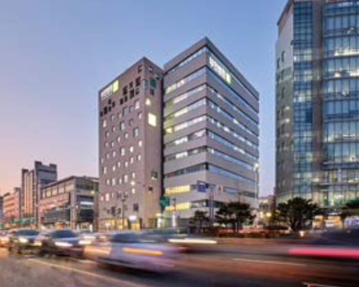 해가 지는 오후에 촬영한 부민병원 전경, 건물 앞 차들이 달리고 있다.