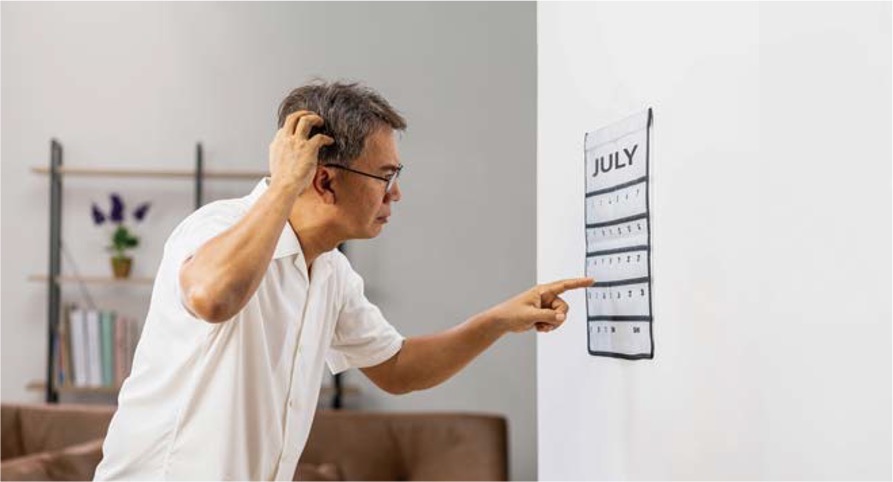 '안경을 쓴 남성이 벽에 걸린 7월 달력을 가리키며 고개를 갸우뚱하거나 머리를 긁적이며 무언가를 생각'한다.