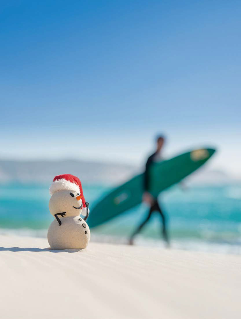 모래로 만든 '눈사람'과 서핑보드를 든 사람이 보이는 호주 해변이다.