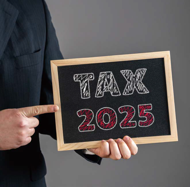 ‘TAX 2025’ 라고 써있는 미니 칠판을 들고 있는 모습이다.