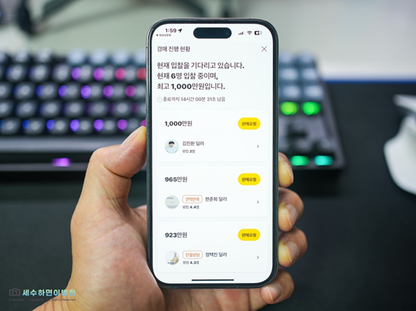 왼손으로 스마트폰을 들고 'KB차차차' 앱 내 '팔아춰차차차' 기능을 활용.  정면, 후면, 계기판 사진 등록 후 '경매 입찰' 단계를 보여주는 이미지.