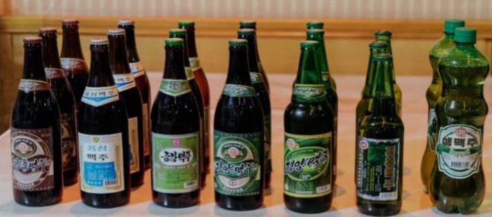'대동강맥주, 평양맥주 등 다양한 북한 맥주 브랜드를 한곳에 모아 촬영한 사진'으로, 제품별 병 디자인과 라벨 차이를 통해 북한 맥주 브랜드의 다양화를 보여주는 이미지다.