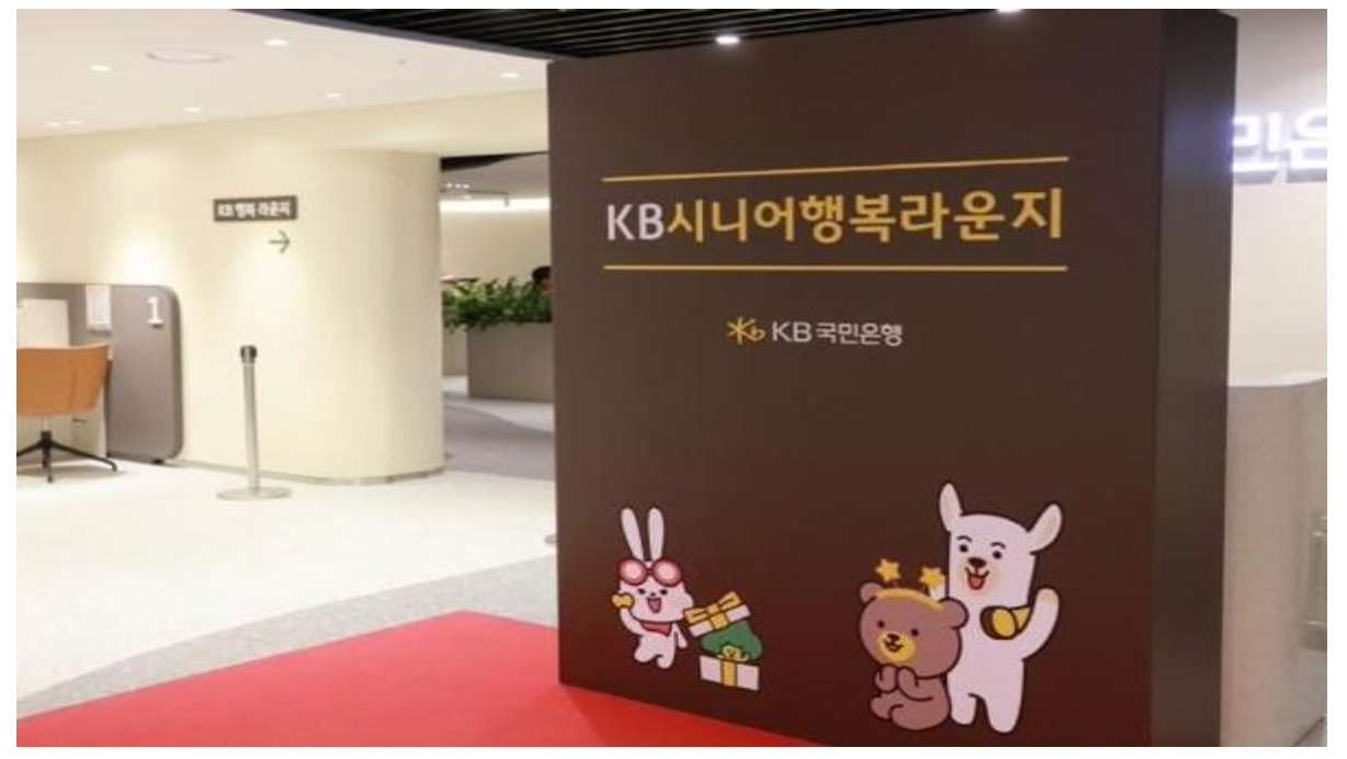 'KB국민은행의 KB 시니어 행복 라운지 안내 공간과 캐릭터 장식이 설치된 모습'을 보여주는 사진이다.