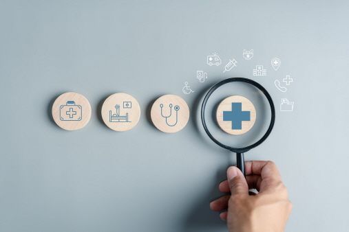 병원 관련 아이콘이 있고 돋보기로 들여다 보는 이미지다.