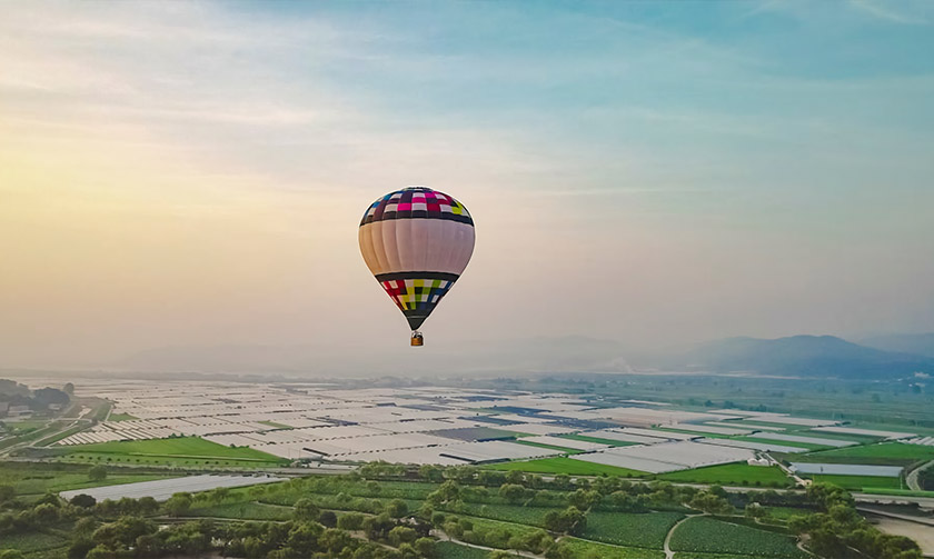 부여의 논밭 위에 높게 올라간 열기구 사진이다.