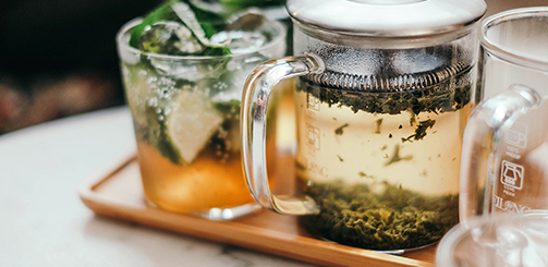 'RELAX'라고 적힌 카페 유리창 너머 따뜻한 조명 아래 사람들의 모습과 함께 '디카페인, 새로운 취향이 되다'라는 문구가 포함된 이미지.