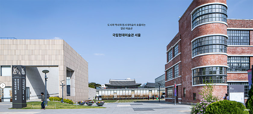 박물관 전시실의 미니멀한 화이트 테이블 위에 놓인 다양한 크기와 모양의 한국 전통 청화백자들. 배경에는 2027년 유료 전환 안내와 박캉스 코스 추천 텍스트가 포함됨