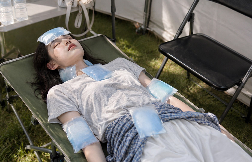 여름철 온열질환 예방을 위해 햇빛 아래서 물을 마시려는 여성과 온열질환 응급 상황 예방 안내 문구