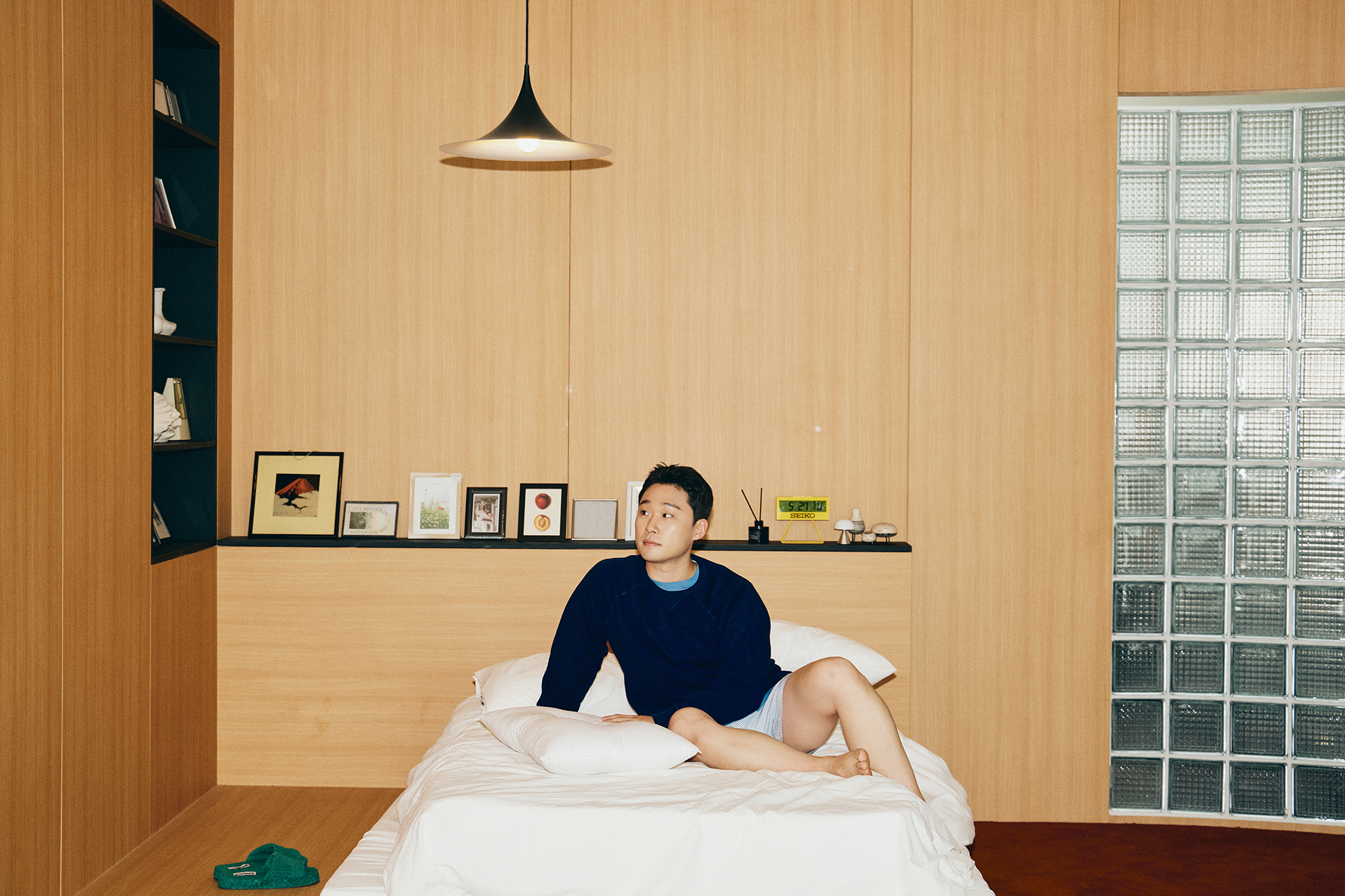 편안한 차림으로 침대에 앉아 있는 자취남