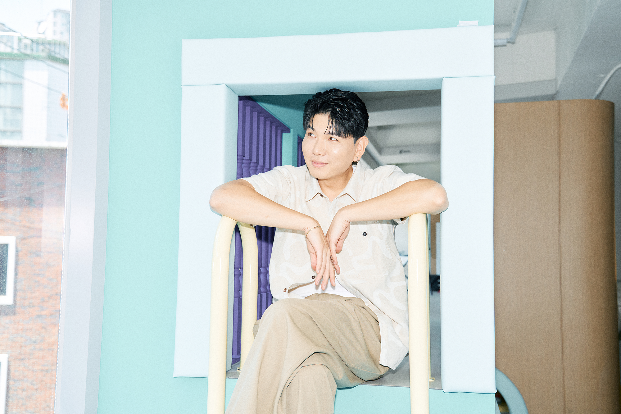키즈카페 놀이공간에 앉아 창밖을 보는 제이쓴