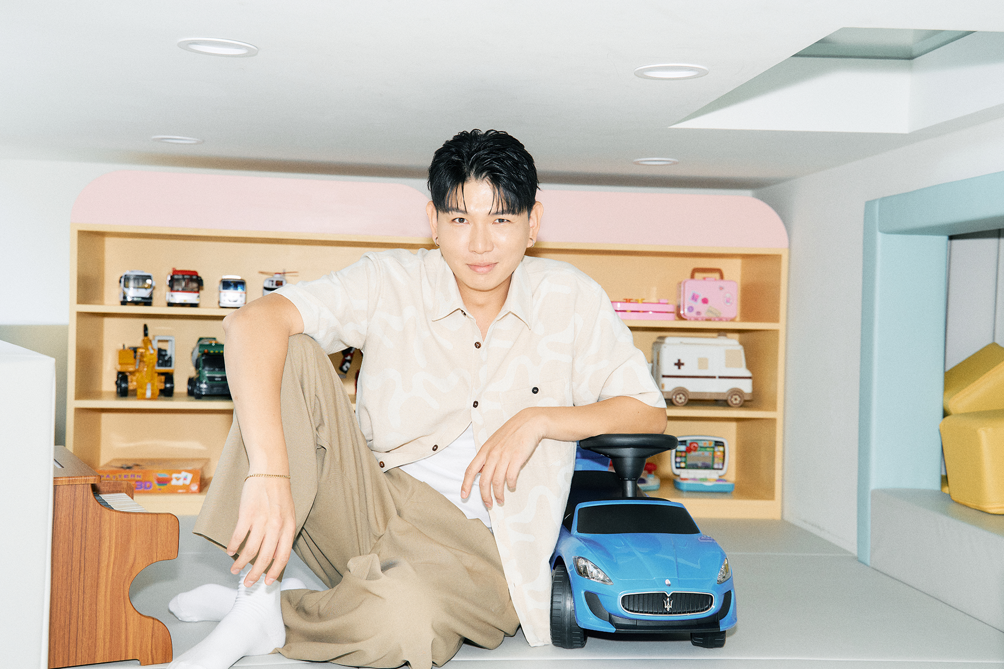 키즈카페에서 장난감 자동차에 팔을 걸치고 앉아있는 제이쓴