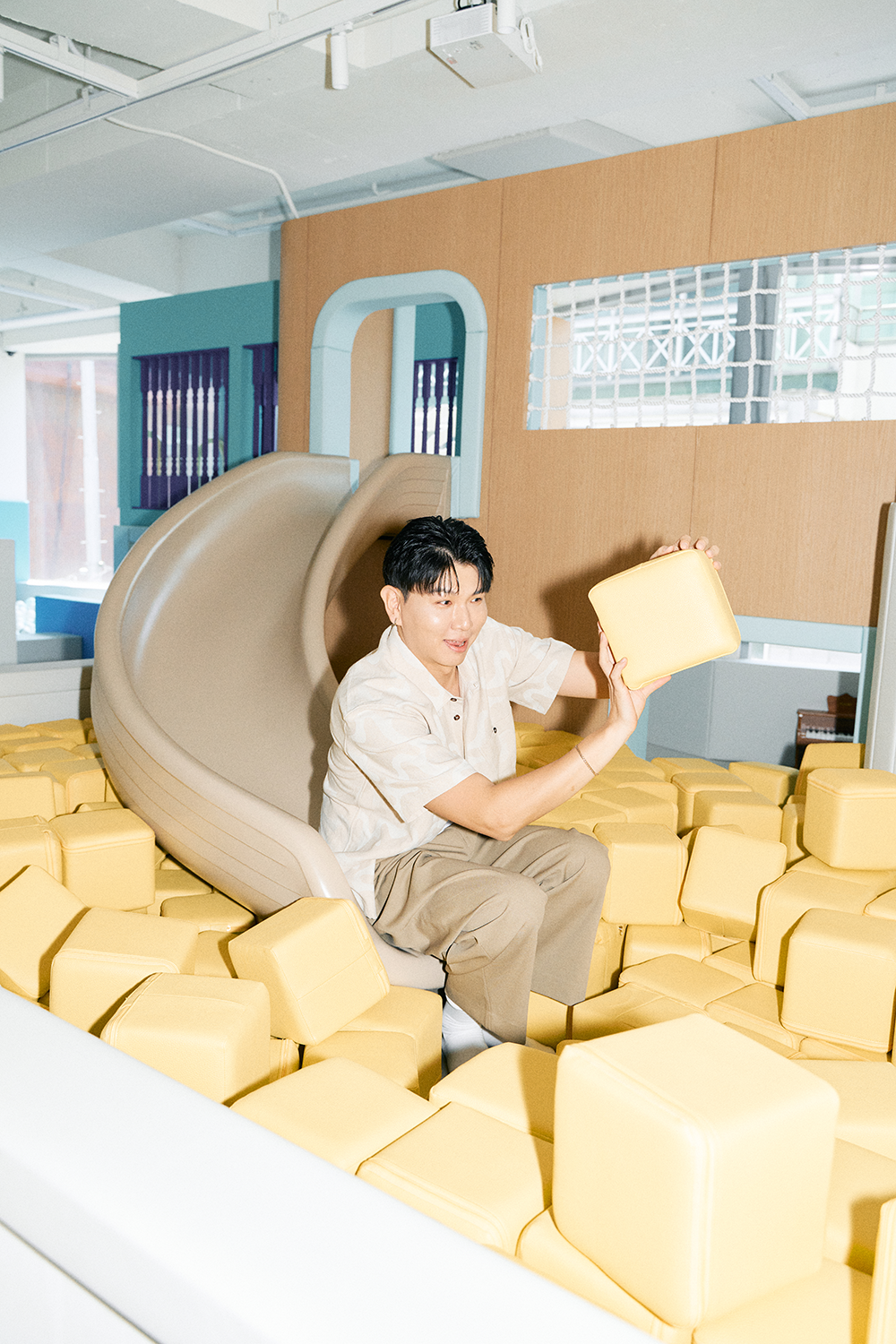 키즈카페 미끄럼틀에 앉아 블럭을 들고 웃고있는 제이쓴