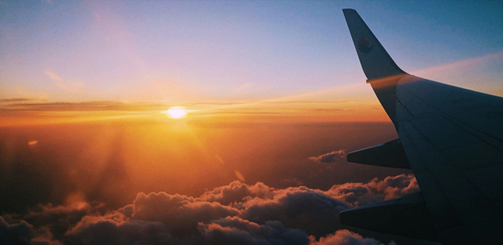 노을이 지는 하늘을 날으는 비행기 날개 쪽 모습이다.
