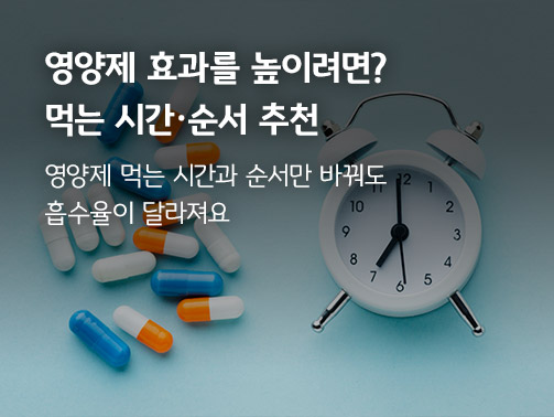 영양제와 탁상 시계가 함께 놓여 있다. 영양제 먹는 시간을 표현한다. 