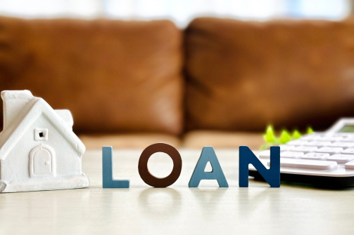 주택 모형 앞에 'LOAN'이라는 영문 글자 모양이 놓여 있다.