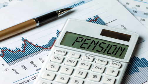 그래프가 그려진 서류 위에 계산기가 올려져 있고 화면에 'pension'이라고 쓰여 있다.
