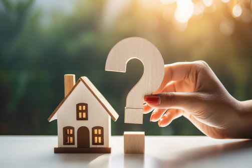 주택 모형 옆에 물음표 모양이 놓여 있다.