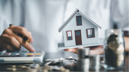 한 손엔 집을 들고 한 손으로는 계산기를 두드리는 사람의 모습.  주택담보대출 연말정산 소득공제 내용을 보조한다.