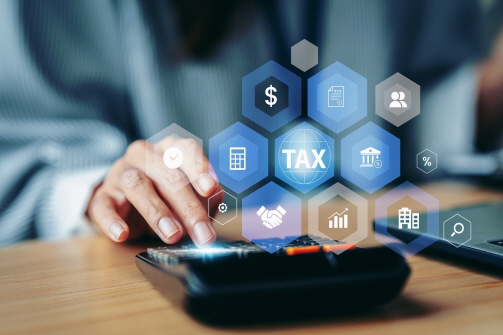 계산기를 두드리는 손 위에 'TAX'라고 써이는 아이콘과 금융을 나타내는 여러 아이콘이 떠있다.