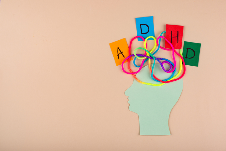 사람 옆 모습위에 알록달록한 실이 엉켜있고 A,D,H,D 한 글자씩 쓰인 종이가 놓여있다.