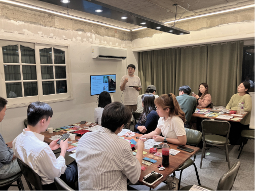 보드게임을 하면서 경제공부를 하는 캐시플로우랩 사진. 모임장이 게임에 앞서 룰을 설명하는 모습.
